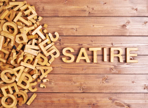 Word satire made with wooden letters — Stock Photo, Image