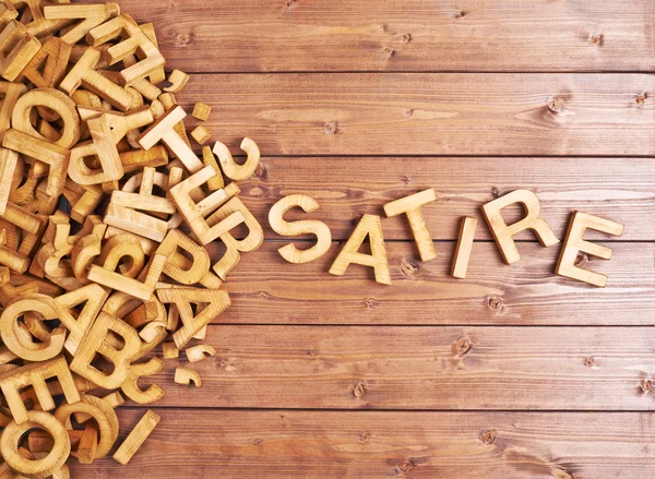 Word satire made with wooden letters — Stock Photo, Image