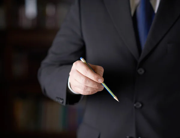 Бизнесмен держит карандаш — стоковое фото
