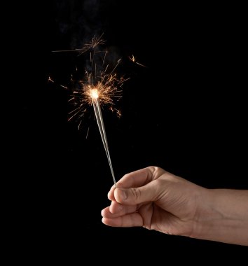 Yanan bir maytap tutan el.