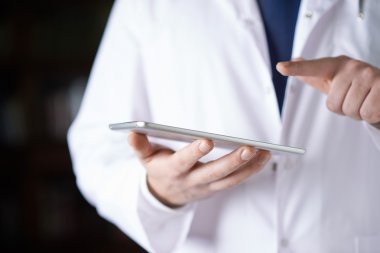 Bir yastık tablet cihaz tutan doktor