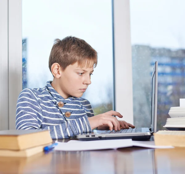 Koncentrerad pojke arbetar på anteckningsboken — Stockfoto