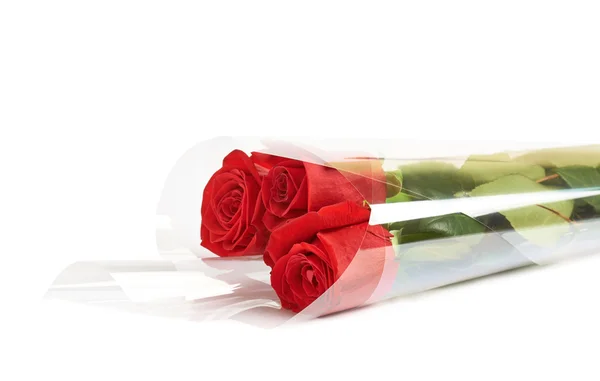 Tres rosas rojas en un envoltorio —  Fotos de Stock