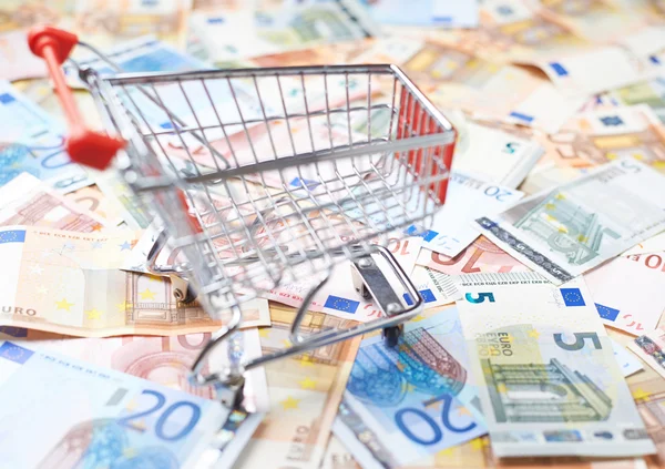 Shopping cart over the banknote bills Royalty Free Stock Photos
