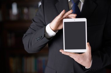 Bir yastık tablet holding iş elbiseli adam