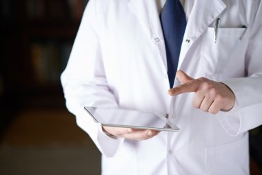 Bir yastık tablet tutan doktor