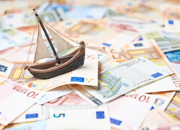 Tiny ship over the bank note bills — Stock Photo, Image