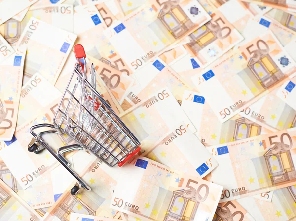 Shopping cart over the bank note bills — Stock Photo, Image