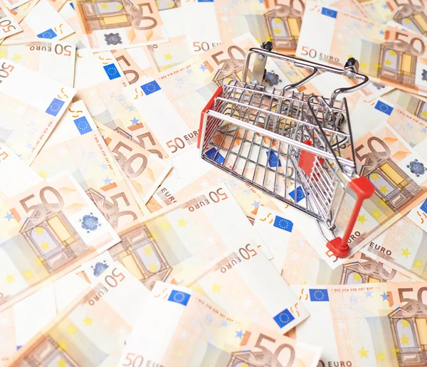 Shopping cart over the bank note bills — Stock Photo, Image