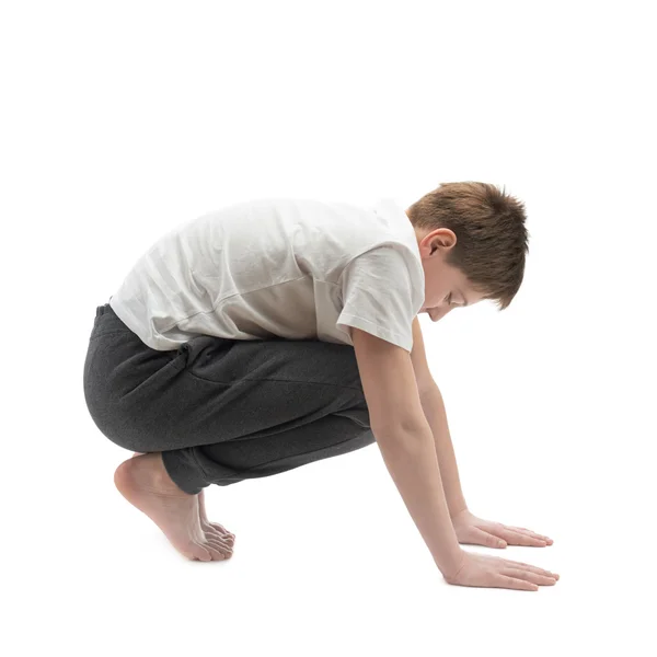 Jeune garçon étirant ou faisant du yoga — Photo