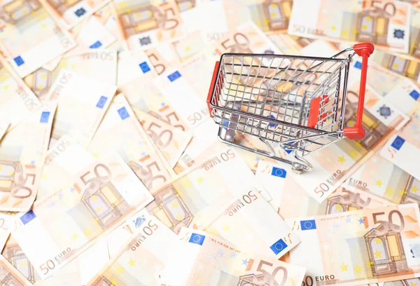 Shopping cart over the bank note bills — Stock Photo, Image