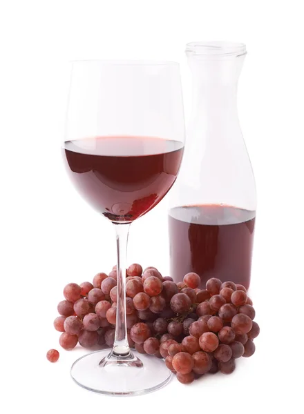 Glass of red wine next to a branch of grapes — Stock Photo, Image
