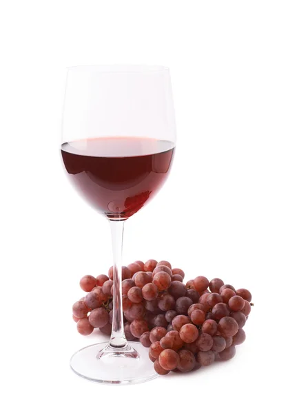 Glas Rotwein neben einem Zweig Trauben — Stockfoto