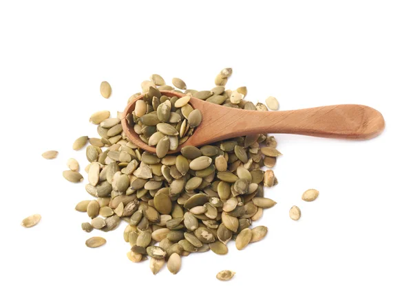 Wooden spoon over pumpkin seeds — Stock Photo, Image