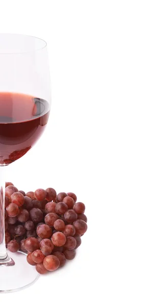 Glas Rotwein neben einem Zweig Trauben — Stockfoto