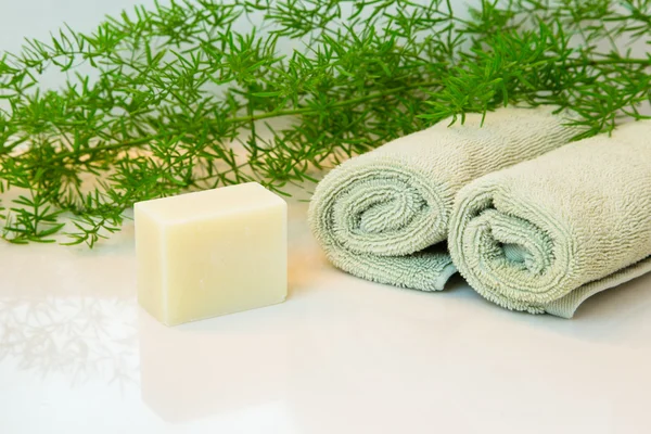 Jabón o barra de champú, toallas y verduras en la encimera del baño —  Fotos de Stock