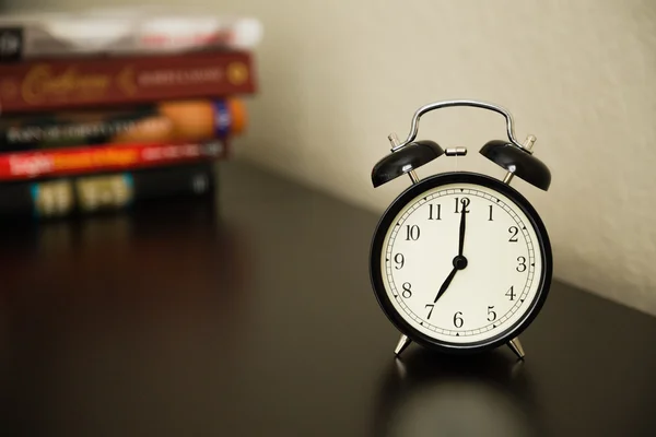 暗い茶色の表面にビンテージの目覚まし時計。7 を示しています。杭 — ストック写真