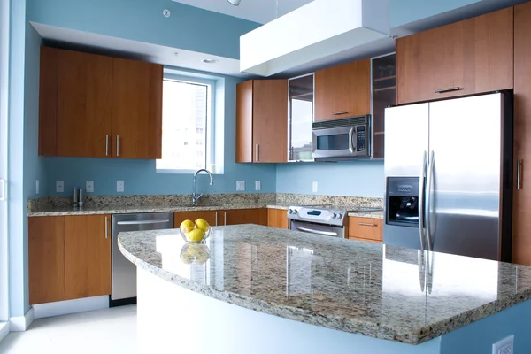 Modern kitchen interior with granite island and wooden cabinets Royalty Free Stock Photos