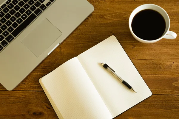 Laptop, notepad and coffee cup on wood table Stock Picture