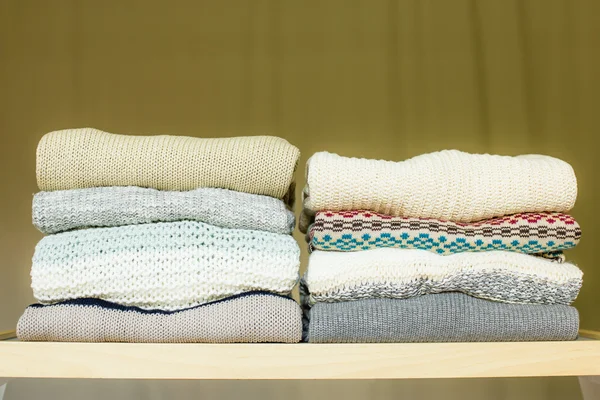 Tumpukan sweater hangat di rak — Stok Foto