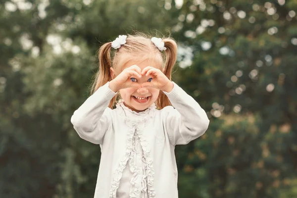Menina Loira Branco Fundo Verde Criança Mostra Coração Com Mãos — Fotografia de Stock