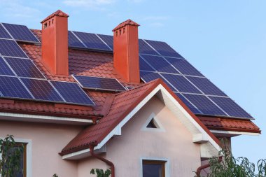 Bacası olan özel bir evin çatısındaki güneş panelleri..