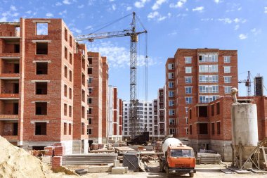 İnşaat alanında beton bir kamyon. İnşaat malzemeleri ve kule vinci olan bir inşaat alanı.