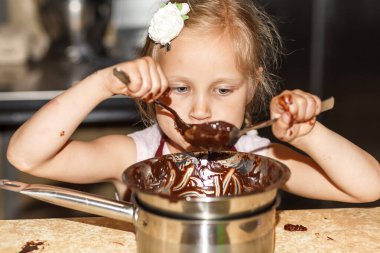 Çocuk sıcak çikolatayla tavaya bakıyor.