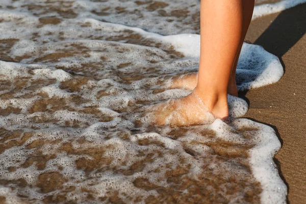 孩子们的腿在海里 孩子们脚踏在海边的沙滩上 — 图库照片