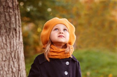 Sonbahar moda çocuğu güz parkı geçmişine bakıyor.