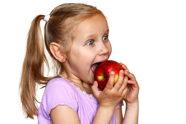 Nöjd Flicka Äter Ett Äpple Med Glädje Vit Bakgrund — Stockfoto