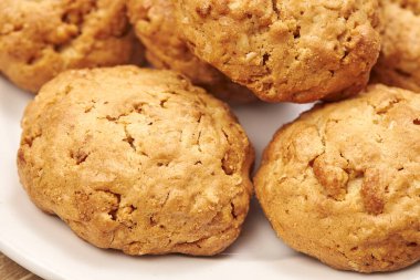 Tahtadaki beyaz seramik tabakta kurabiyeler.