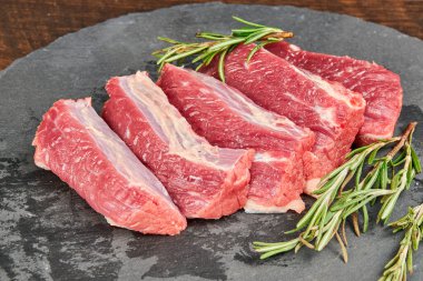 Biberiyeli ahşap masada çiğ biftek.