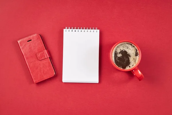 Červený psací stůl s poznámkou, smartphonem a šálkem kávy. — Stock fotografie