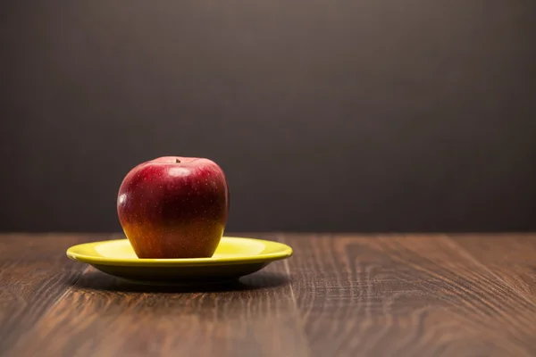 Red apple on plate — Stock Photo, Image