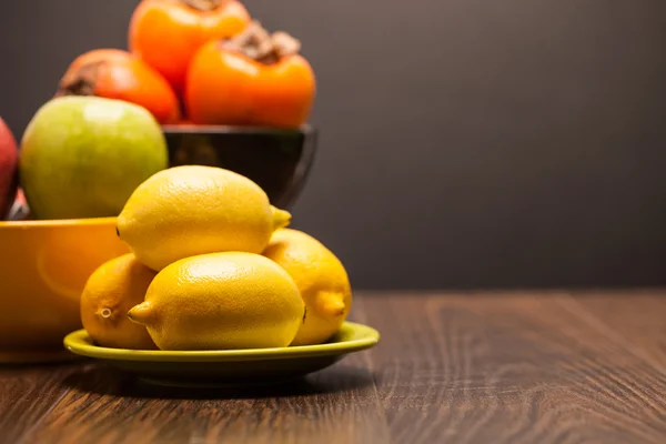 Fresh lemons on plate — Stock Photo, Image