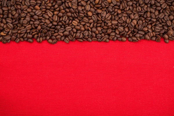 Kırmızı arkaplanda kahve çekirdekleri — Stok fotoğraf