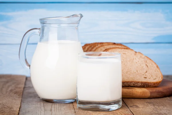 Brotscheiben, Milch auf einem Holztisch — Stockfoto