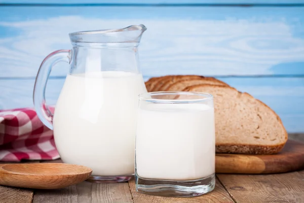 Brotscheiben, Milch auf einem Holztisch — Stockfoto