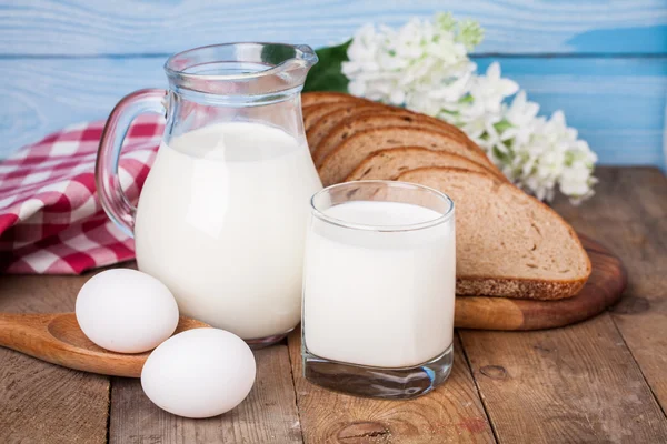 Ψωμί, αυγά και γάλα γυαλί στο ξύλινο τραπέζι — Φωτογραφία Αρχείου