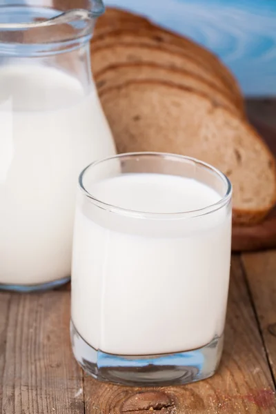 Brotscheiben, Milch auf einem Holztisch — Stockfoto