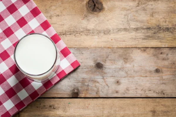 Milch im Glas auf einem Holztisch — Stockfoto