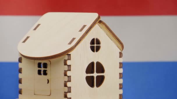 Malý dřevěný domek, nizozemská vlajka na pozadí. Koncept nemovitostí, měkké zaměření — Stock video