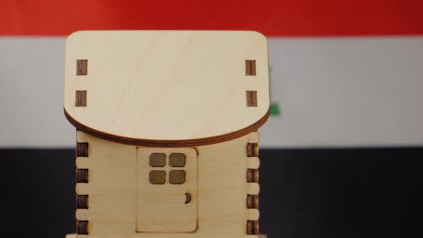 Malý dřevěný domek, irácká vlajka na pozadí. Koncept nemovitostí, měkké zaměření — Stock video