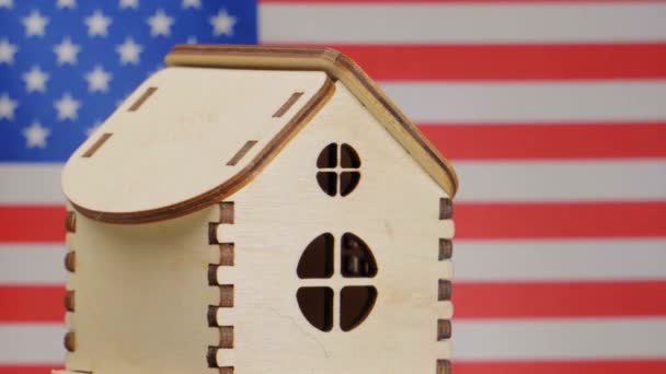 Kis faház, amerikai zászló a háttérben. Ingatlankoncepció, lágy fókusz — Stock videók