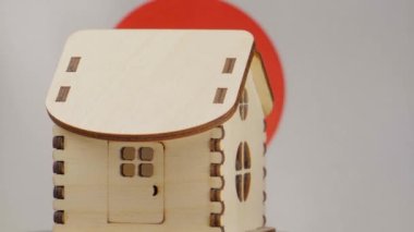 Küçük ahşap ev, arka planda Japonya bayrağı. Gayrimenkul kavramı, yumuşak odaklanma