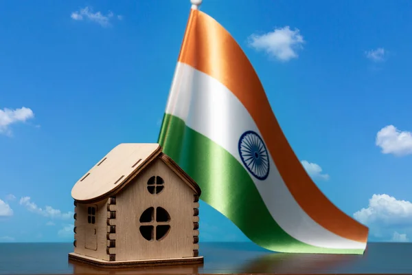 Μικρό ξύλινο σπίτι και την Ινδία σημαία, ουρανός στο παρασκήνιο. έννοια ακινήτων, αντίγραφο χώρου — Φωτογραφία Αρχείου
