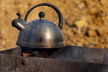 Izgarada eski metal çaydanlık, yakın plan.