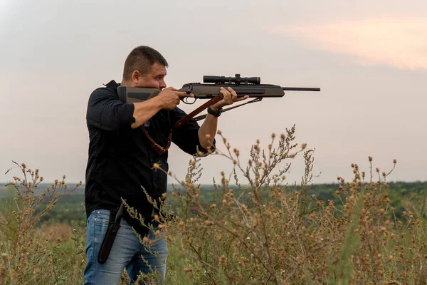 Europeaan schiet een geweer met een optisch zicht. Portret van een schutter met een geweer — Stockfoto