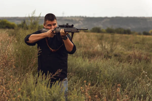 Portret van een schutter met een geweer. Europeaan schiet een geweer met een optisch zicht — Stockfoto